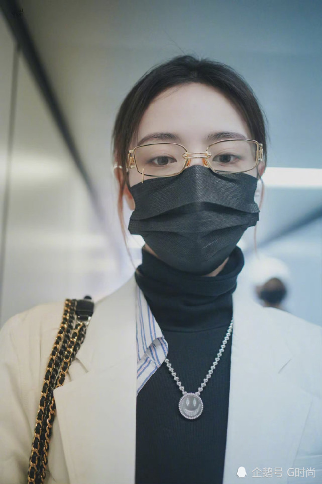 许佳琪身穿黑色打底衫搭配白色大衣金属框眼镜加持尽显精致优雅