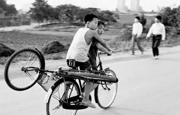 90年代老照片:1995年,在河南平頂山,一名小男孩騎著自行車,不僅前面帶