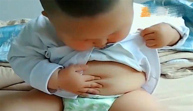萌娃研究自己肚子上的肉肉发现妈妈在偷拍后脸上的表情太搞笑