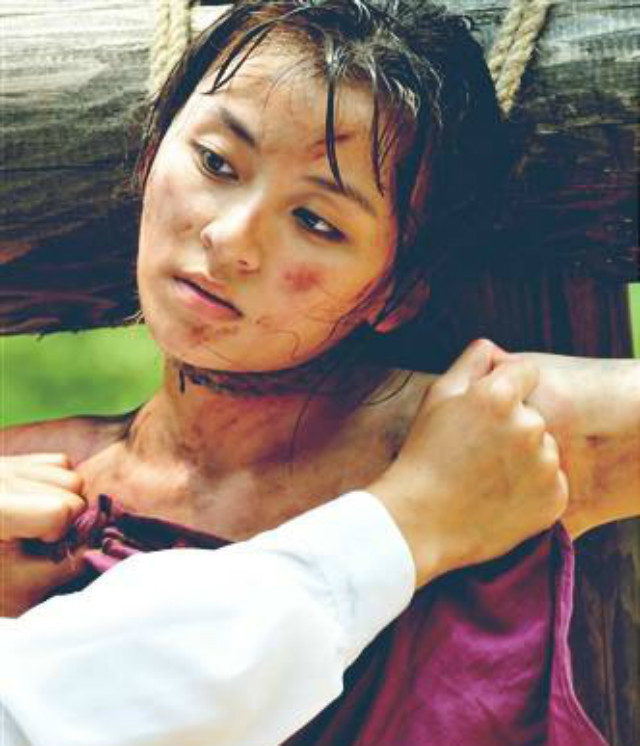 一个美貌的少女从车上缓缓走下,只见她双手反绑,脚上戴着脚镣.