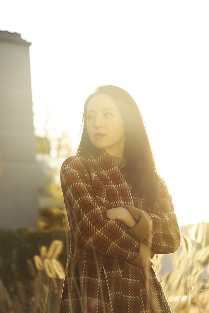 董璇发丝飘逸穿格纹大衣浅笑迷人置身阳光下自在随性意境温暖