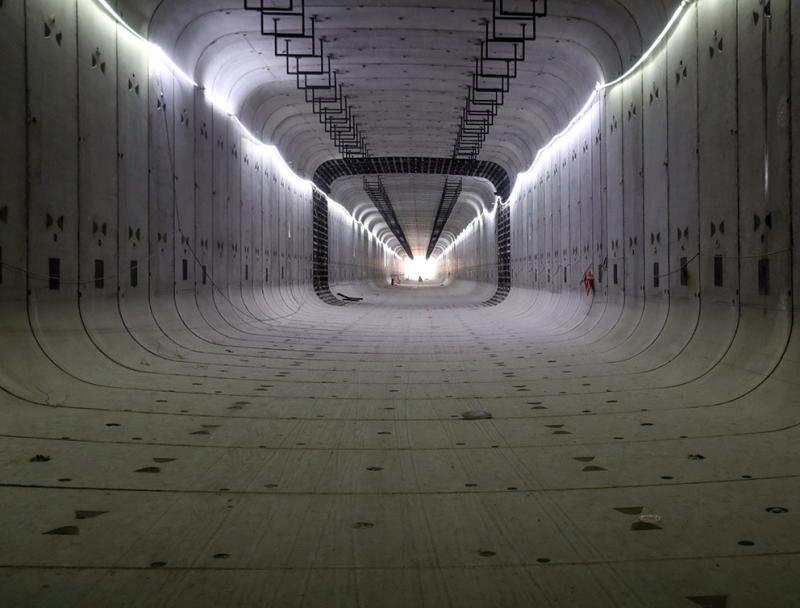 陆翔路-祁连山路贯通工程中的"东隧"矩形顶管已贯通,工人在安装灯架.