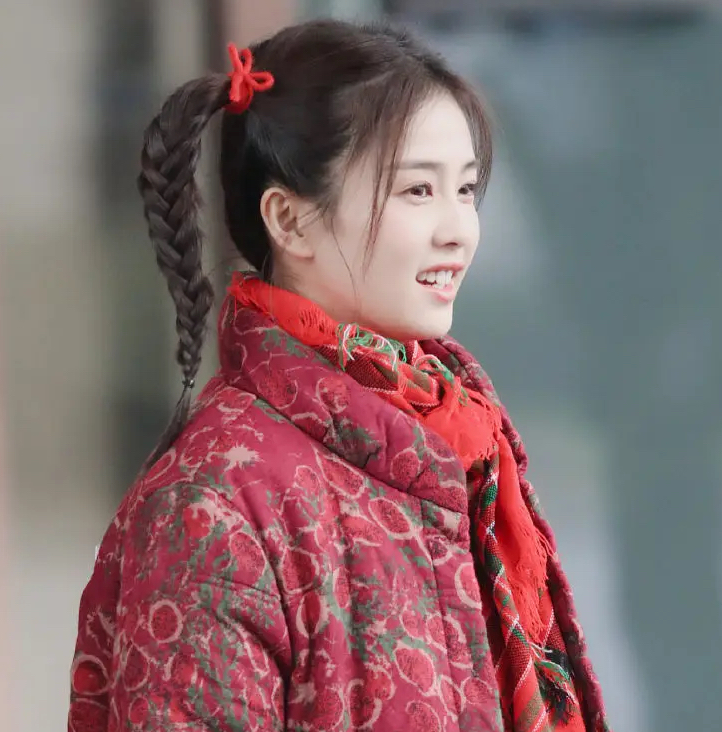 却扮上了扎着两个羊角辫,穿着红色的喜庆棉袄,一个像是傻妞一样的角色