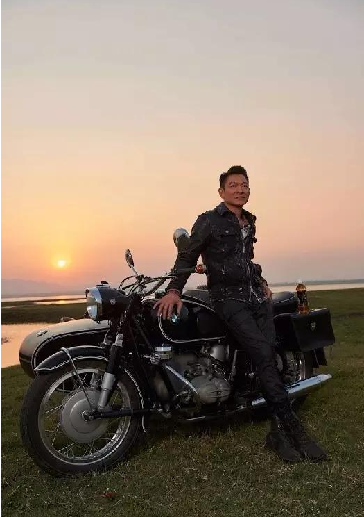摩托车,背后是夕阳落山的景色,谁能猜出这个时候的刘德华已经是五十多