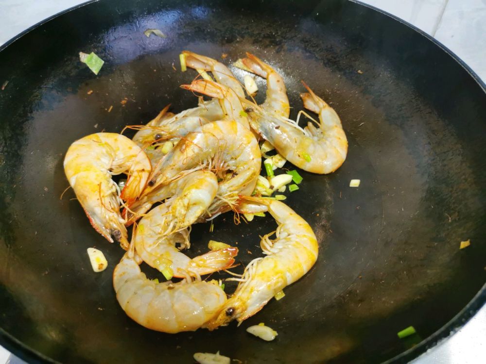 步骤5 准备一个炒锅,放入少许食用油,锅开小火,油热下入虾头,小火煸炒