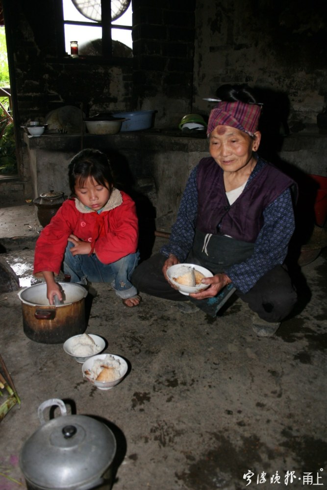 2006年4月,张秋梅在给奶奶盛饭.