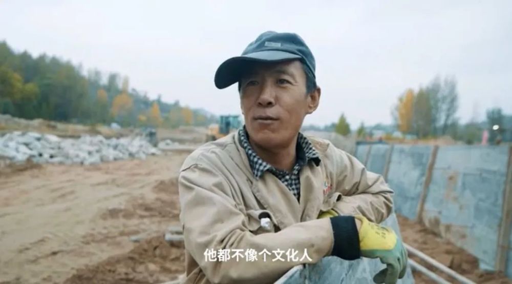 视频中,一身工装的李小刚穿着与万千农民工人无异.