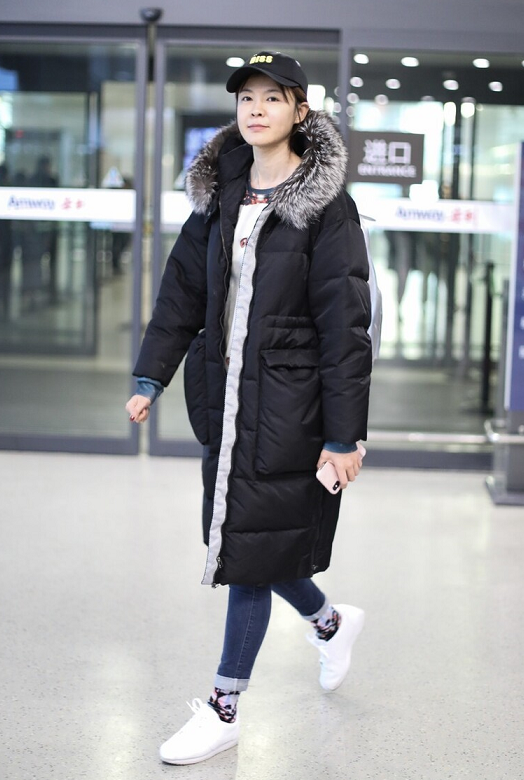 李艾衣服品味不错穿长款羽绒服搭配牛仔裤走机场保暖又洋气