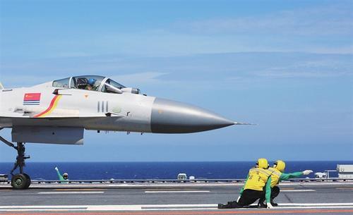 航母飞行甲板上身着黄色服装的舰员在指挥引导舰载战斗机起飞