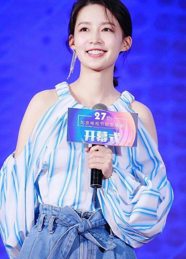 白蓝色的条纹让她更加眉清目秀,微微的扎起低马尾和链条耳饰,李沁的