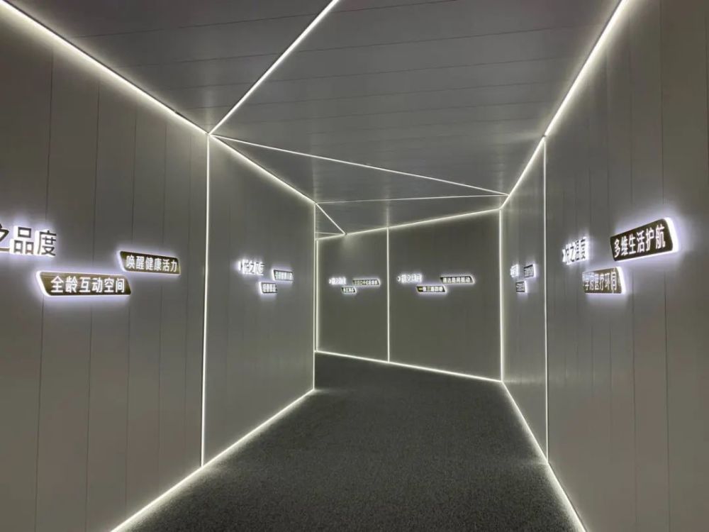 进入样板间通道,浅色内墙搭配暖黄发光线条,勾勒出简约的美学效果