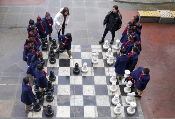 重庆市九龙坡区杨石路小学校2年级7班的学生们在国际象棋兴趣课上和