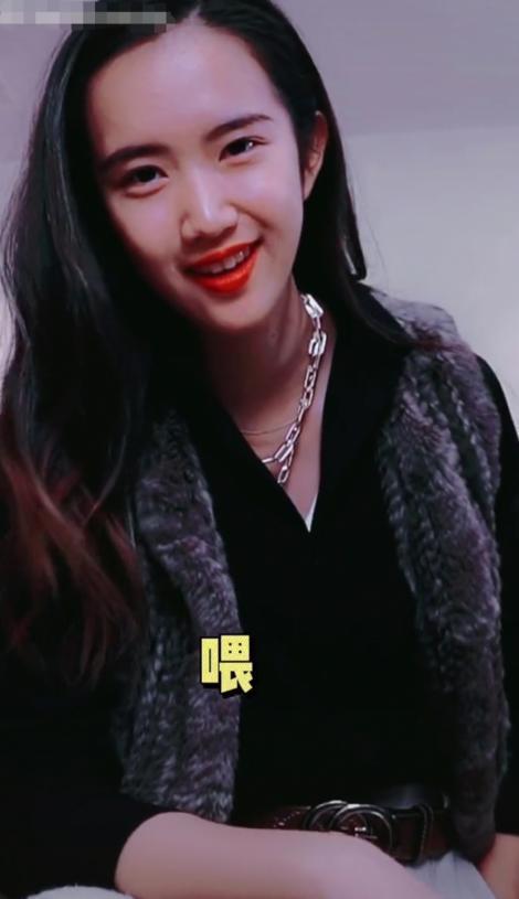 从视频中可以看出,骆达华坐在沙发上,而骆欣言则身穿黑色外套,浅灰色