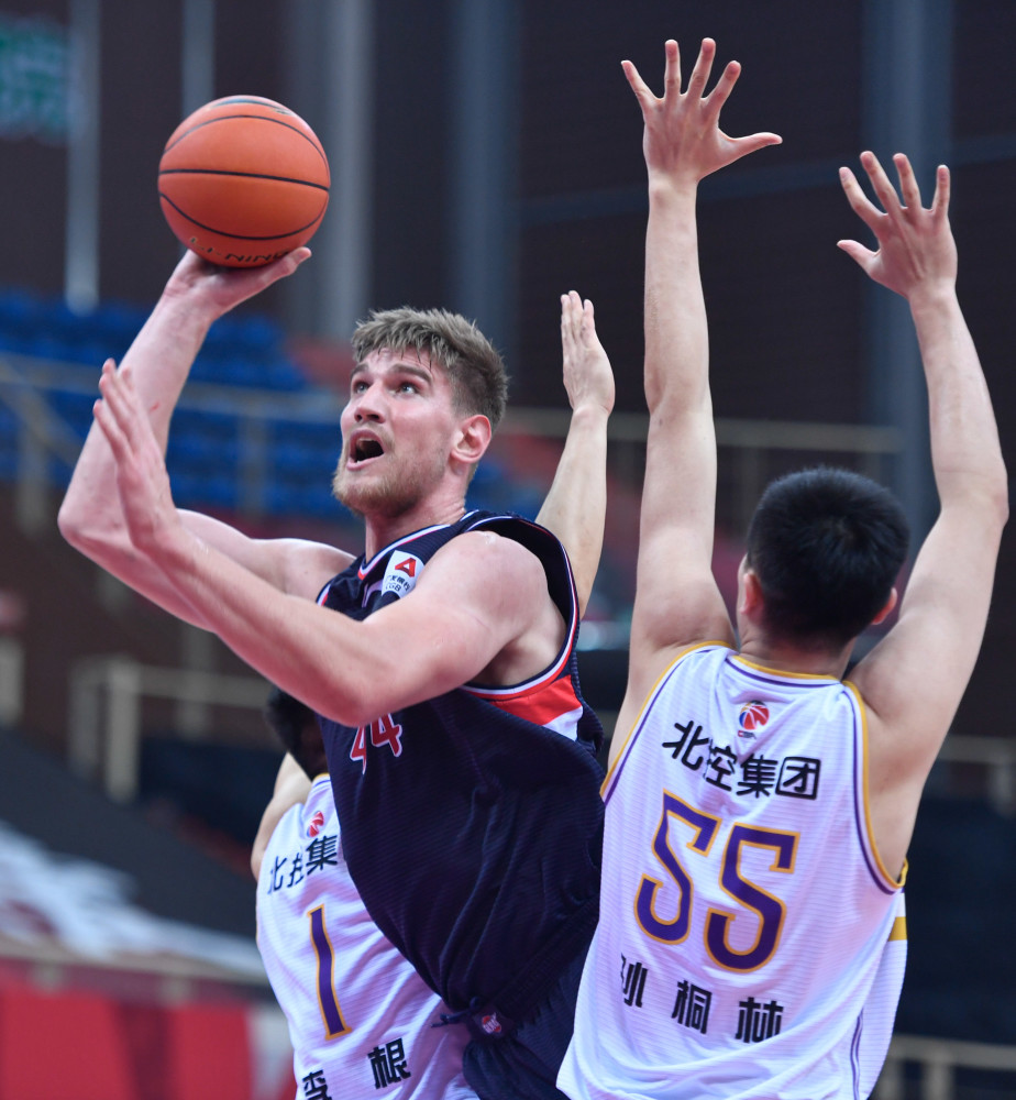 12月13日,时代中国广州队球员哈斯(左)在比赛中上篮.