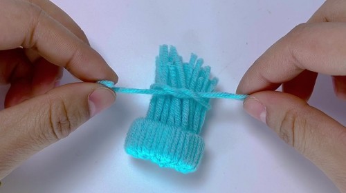 6. 全部拉出来后,用一根毛线,将毛线顶部打结,系紧.