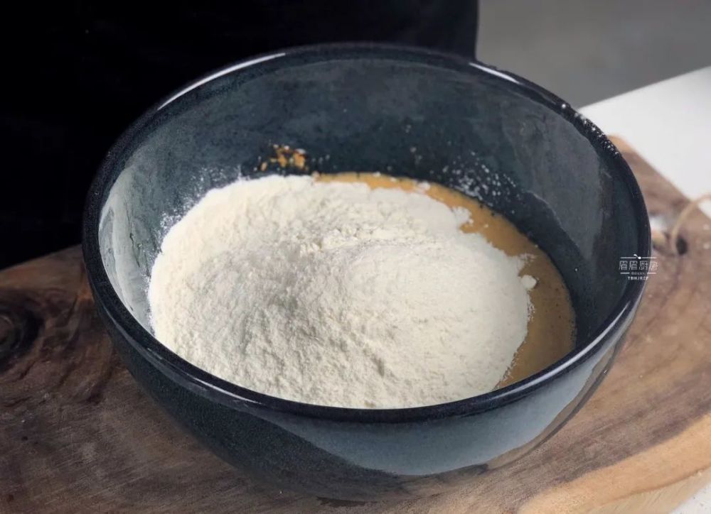 2,充分搅拌均匀,倒入300克面粉,边倒边搅拌成絮状