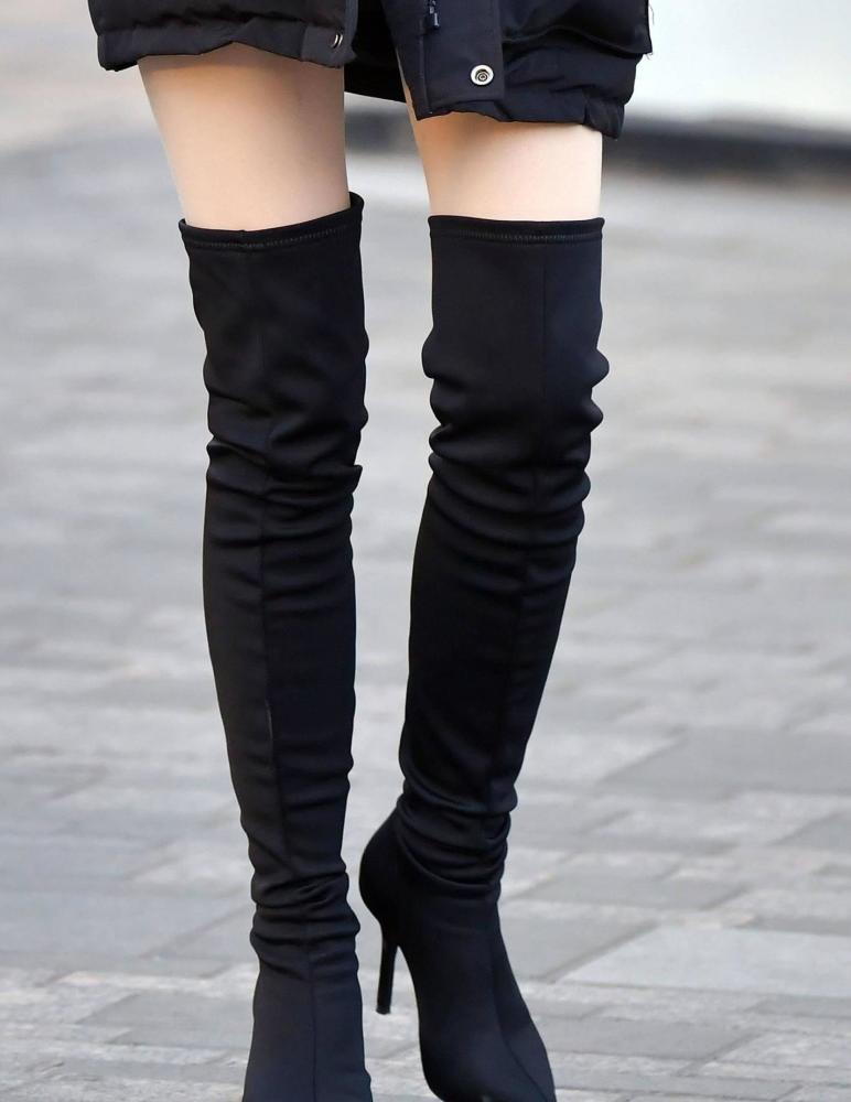 黑色的尖头细跟过膝长靴搭配一款黑色羽绒服时髦又很保暖显高