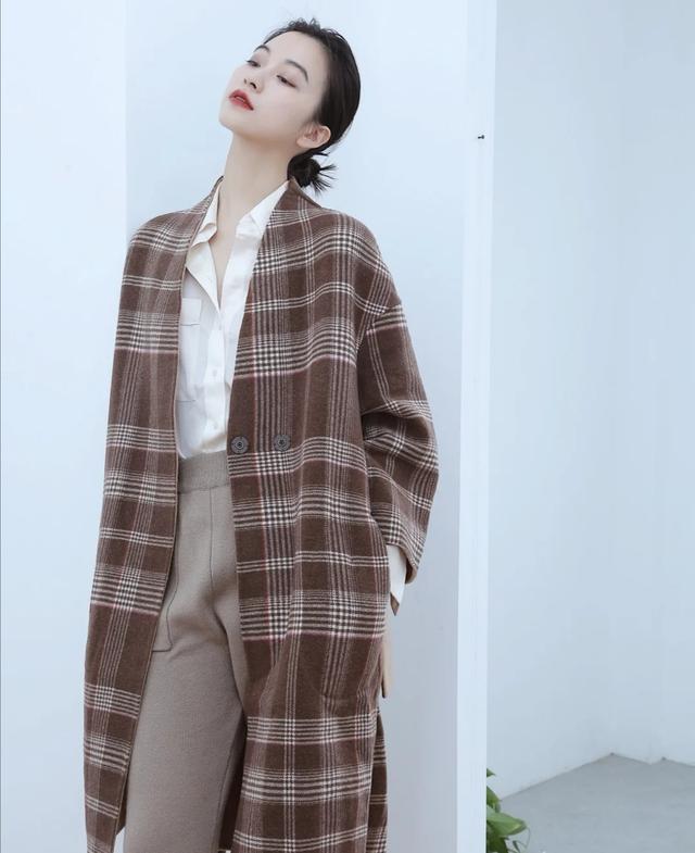 同样可以考虑顺色搭配,一件棕色格子毛呢大衣,搭配上浅咖色毛呢裤