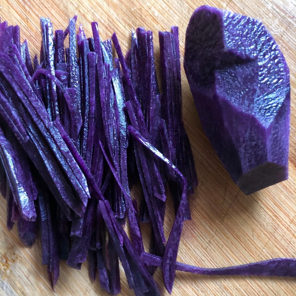 第4步,紫色土豆丝焯水,在这个过程中加一点盐,让土豆丝更加脆嫩.
