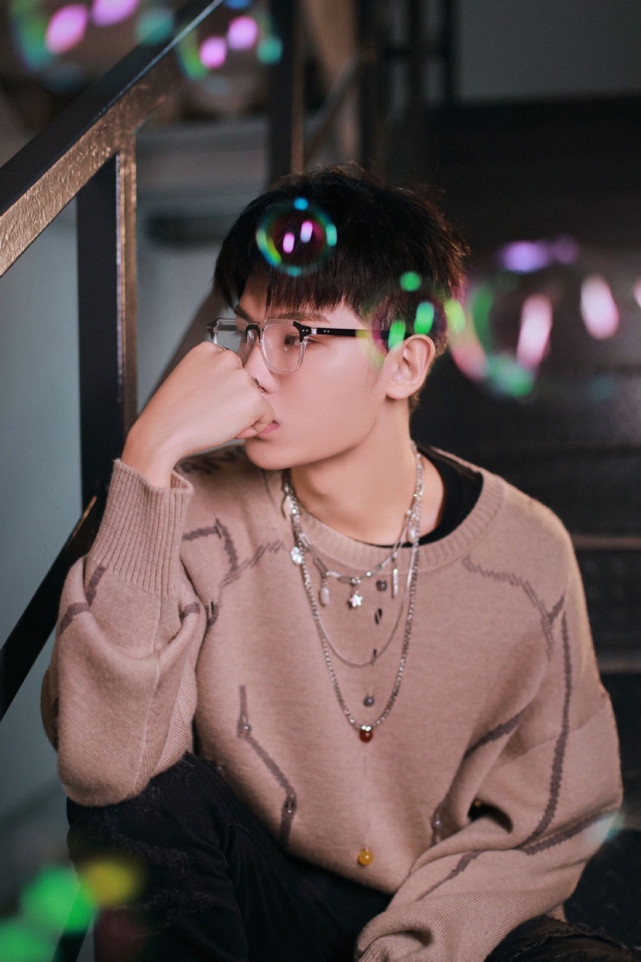 黄明昊最新综艺造型图卡其色针织毛衣搭配黑框眼镜少年感十足