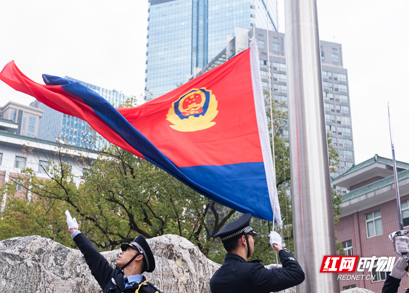 由24名特警队员组成的护卫方阵,护着中国人民警察旗,正步走向升旗台.