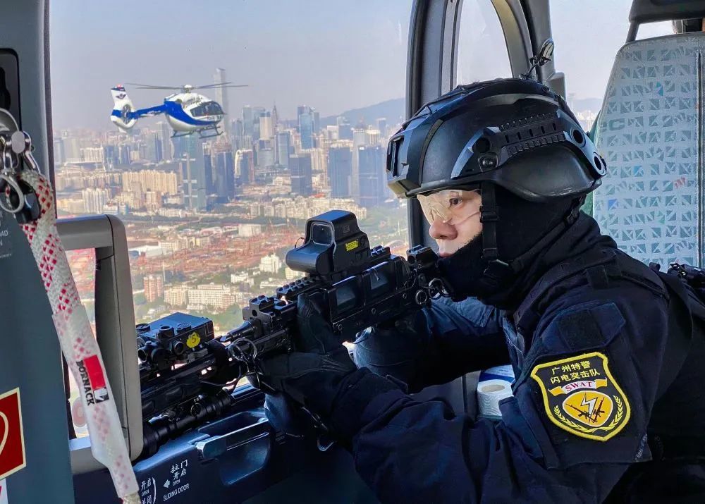 广州特警闪电突击队队员从警航直升机上警戒,编队中的另一架直升机将