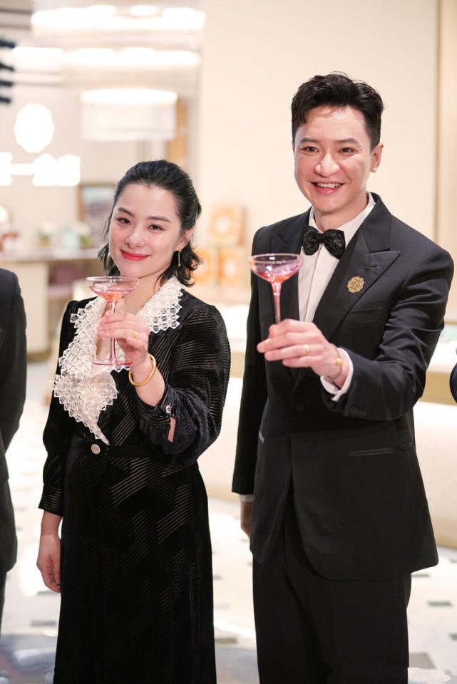 王弢直接选择了与老婆颜色呼应的西服套装,内穿白衬衫下穿黑色翻领