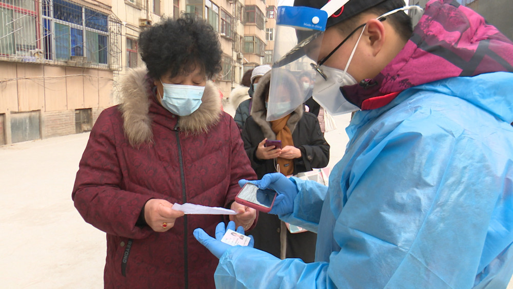 1月14日,在山西省晋中市榆次区锦纶街道核酸采样点,志愿者李泽华(右二