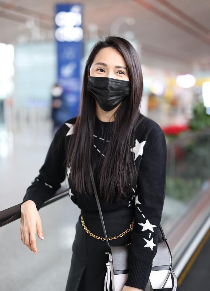 52岁伊能静少女感十足穿链条短裙走机场甜笑比心好随意