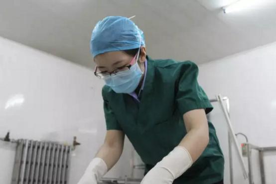 验尸时怀孕7个月的女法医把警徽放在肚子前