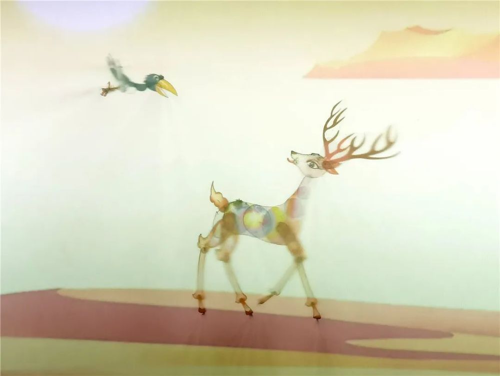九色鹿时而在幕布后,时而腾空跃至台前,化身荧光鹿,皮影与投影以一正