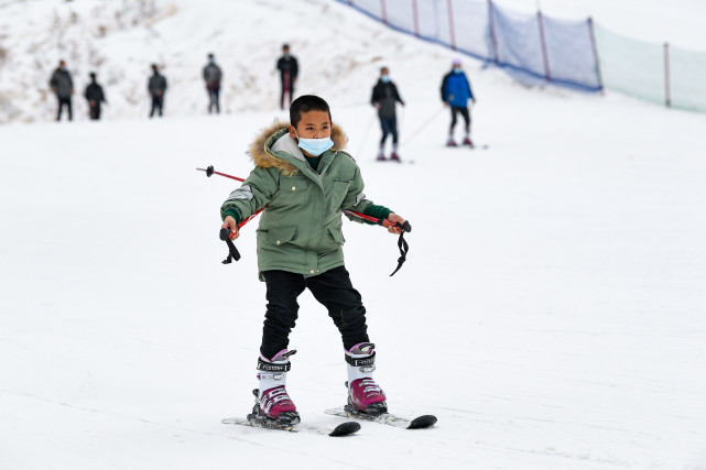 1月20日,一名小朋友在寧夏固原市涇源縣婭豪國際滑雪場練習滑雪.