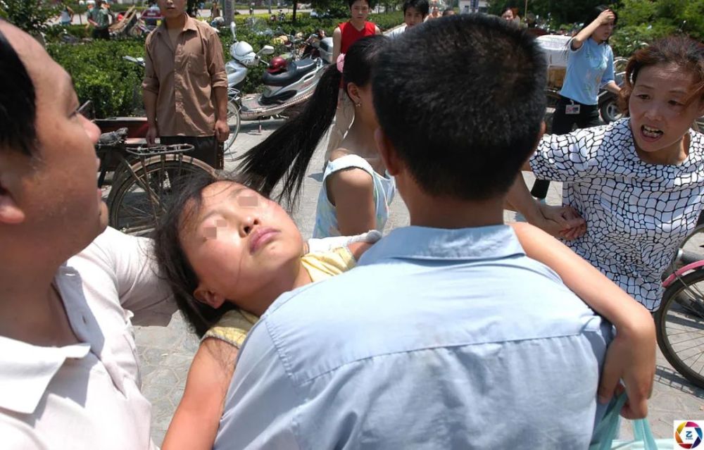 图为由于惊吓,小女孩昏厥过去.紧接着,嫌疑人的尸体被抬出来.