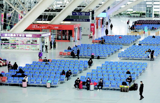 一名学生身穿防护服准备回淄博老家.在青岛北站候车的乘客.