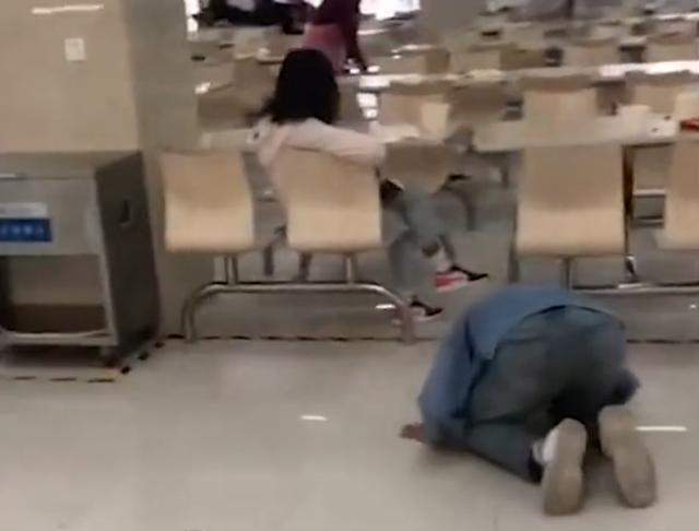 在河南某大学食堂,一名男生跪在地上给坐在椅子上的女生磕头.