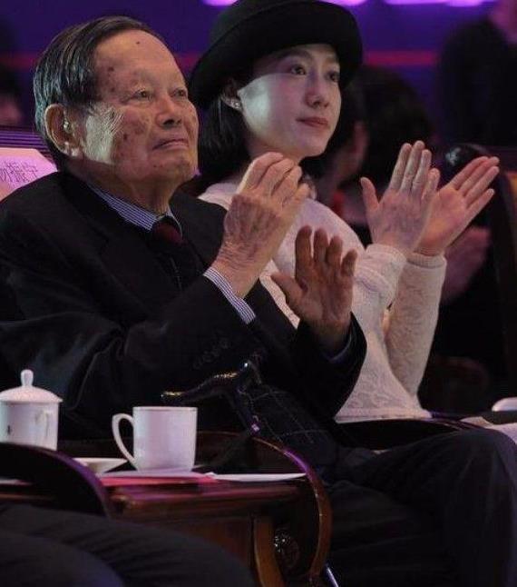 翁帆牵手杨振宁现身，44岁的脸还很稚嫩，穿格子裙又很优雅！