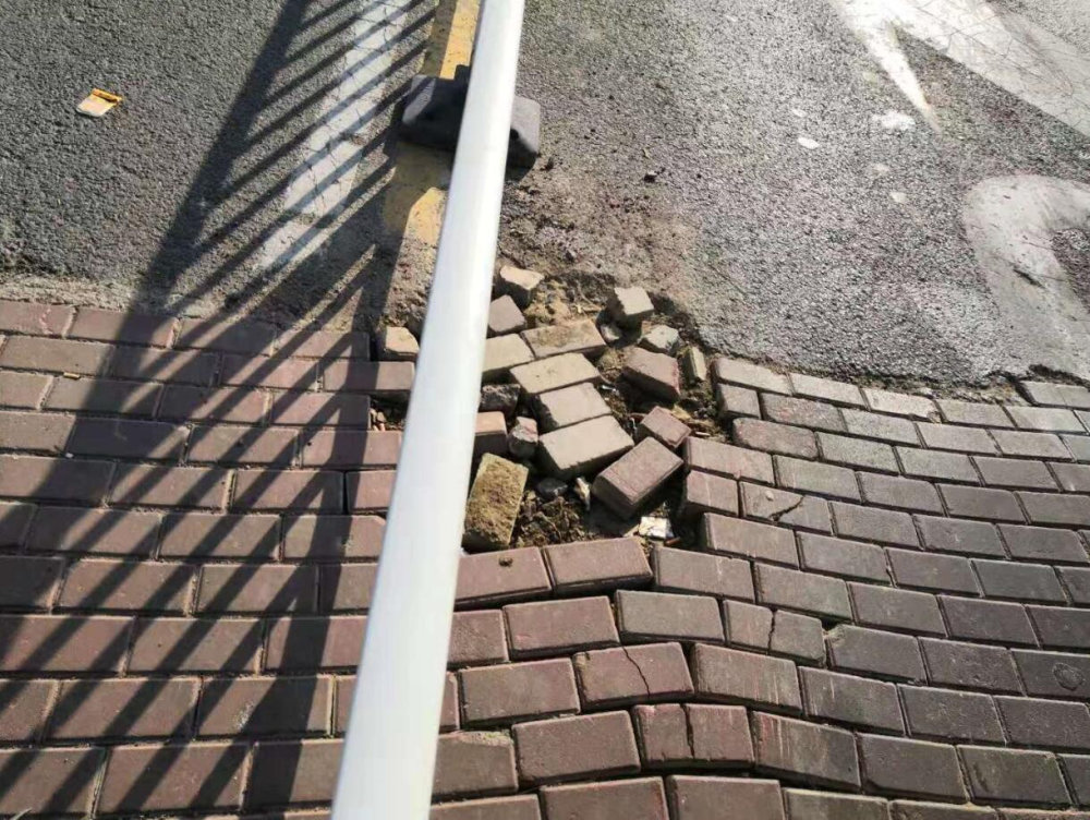 记者走近发现,道路东侧由于少了几块砖,路面有些塌陷.