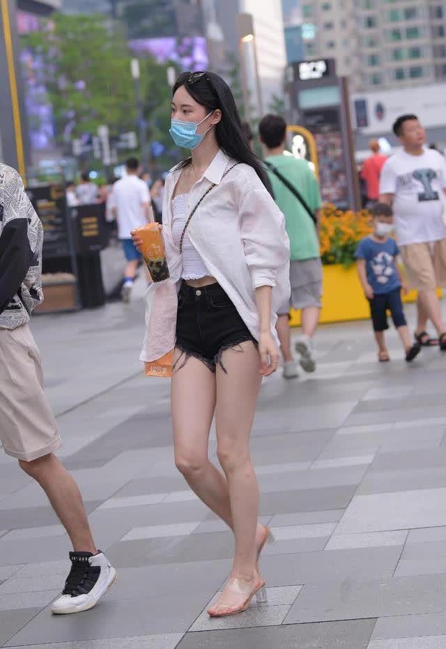 白色衬衫搭配黑色短裤美女虽然戴着口罩但身材和气质无法遮挡