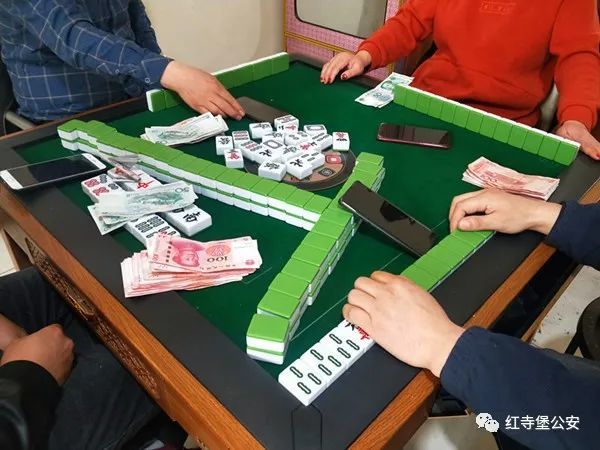 瞬间,围坐在牌桌旁的三男一女表情惊愕,桌面上摆放着零散的麻将和现金