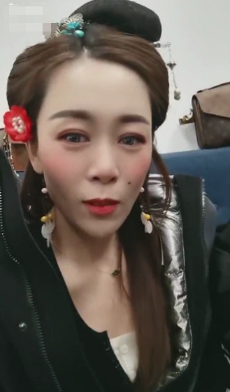 视频中,杨晓茹脸上化着精致的妆容,头上和耳朵上戴着古代饰品,为了