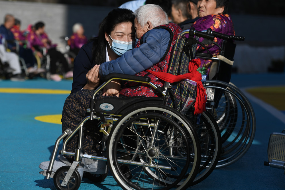 2月5日,在深圳龙华区晚晴苑养护院,徐岩岩在户外与老人互动