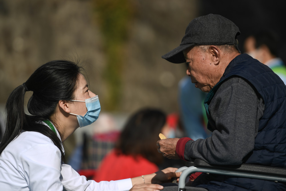 2月5日,在深圳龙华区晚晴苑养护院,徐岩岩与老人交流