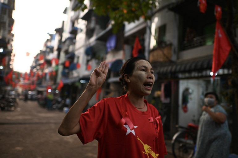 在缅甸仰光,一名妇女举起三指抗议,呼吁释放被拘禁的平民领袖昂山素季