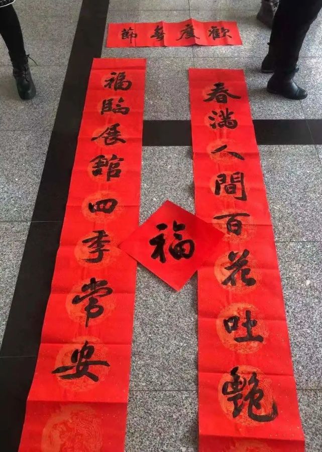 贴春联后勤集团的工作人员为食堂和学生公寓挂起年味十足的拉花与福字