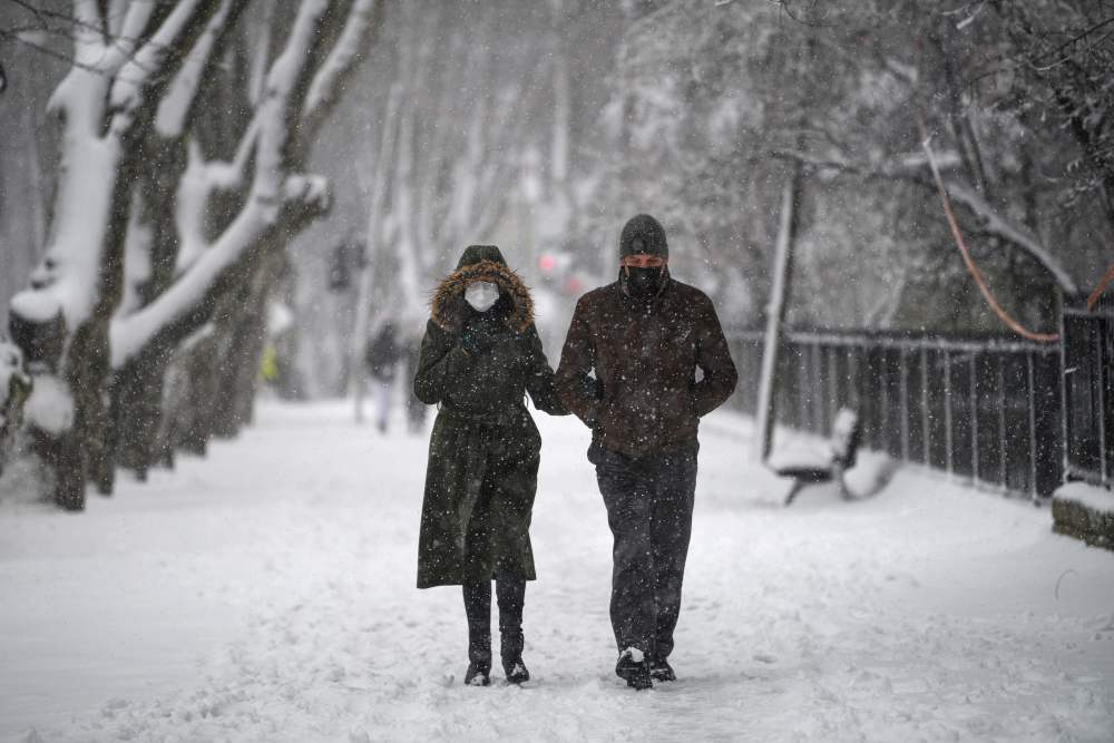 2月14日,一对情侣在土耳其伊斯坦布尔雪中行走.