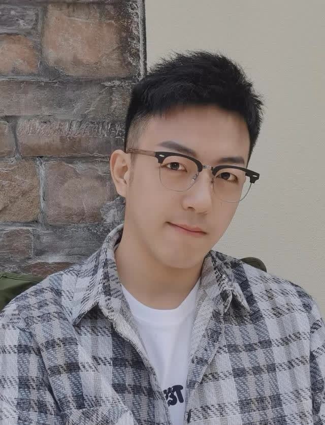 小哥哥长相清秀帅气,带着眼睛抿嘴的模样可爱极了,一副黑框眼镜架在高