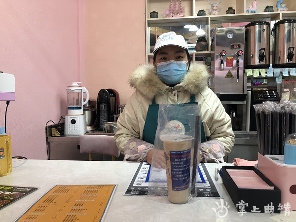 "2月19日,在双龙街道一奶茶店,店长小宁笑意盈盈地把奶茶递到顾客手中