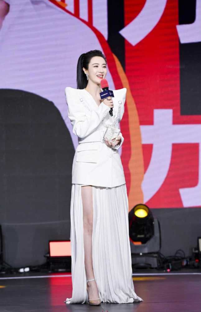 将一条腿很自然地展现出来,搭配一双白色简约的高跟凉鞋,与裙子的颜色