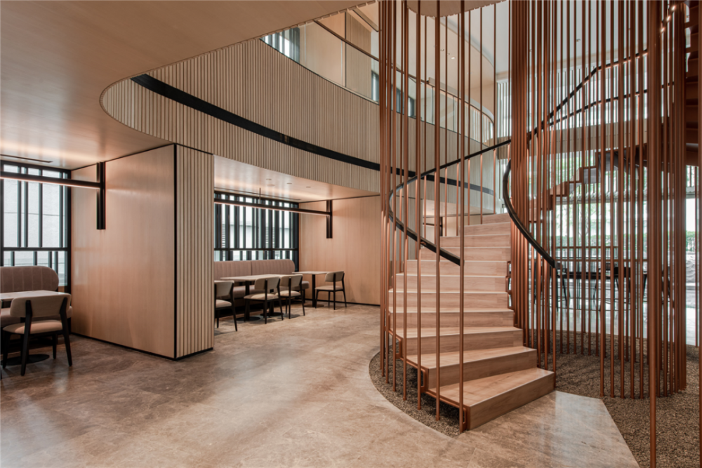 黄铜金属镂空细圆管包围着螺旋楼梯,兼具功能性和艺术性,就像一根根崩