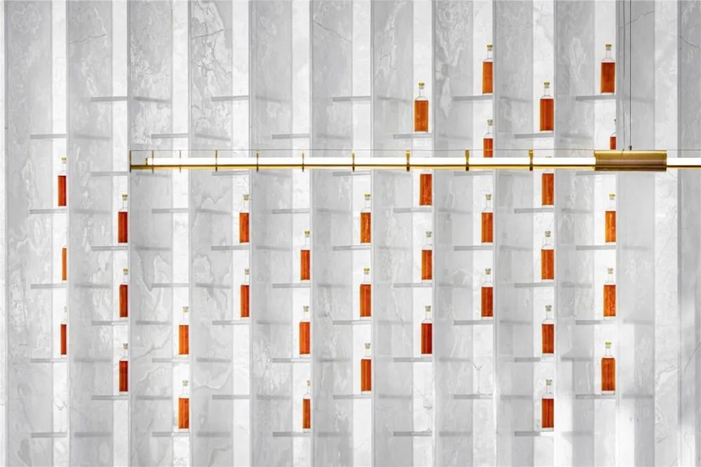 玉石隔断的有序阵列结构,延续至水吧,成为背景墙与酒架合一的功能体.